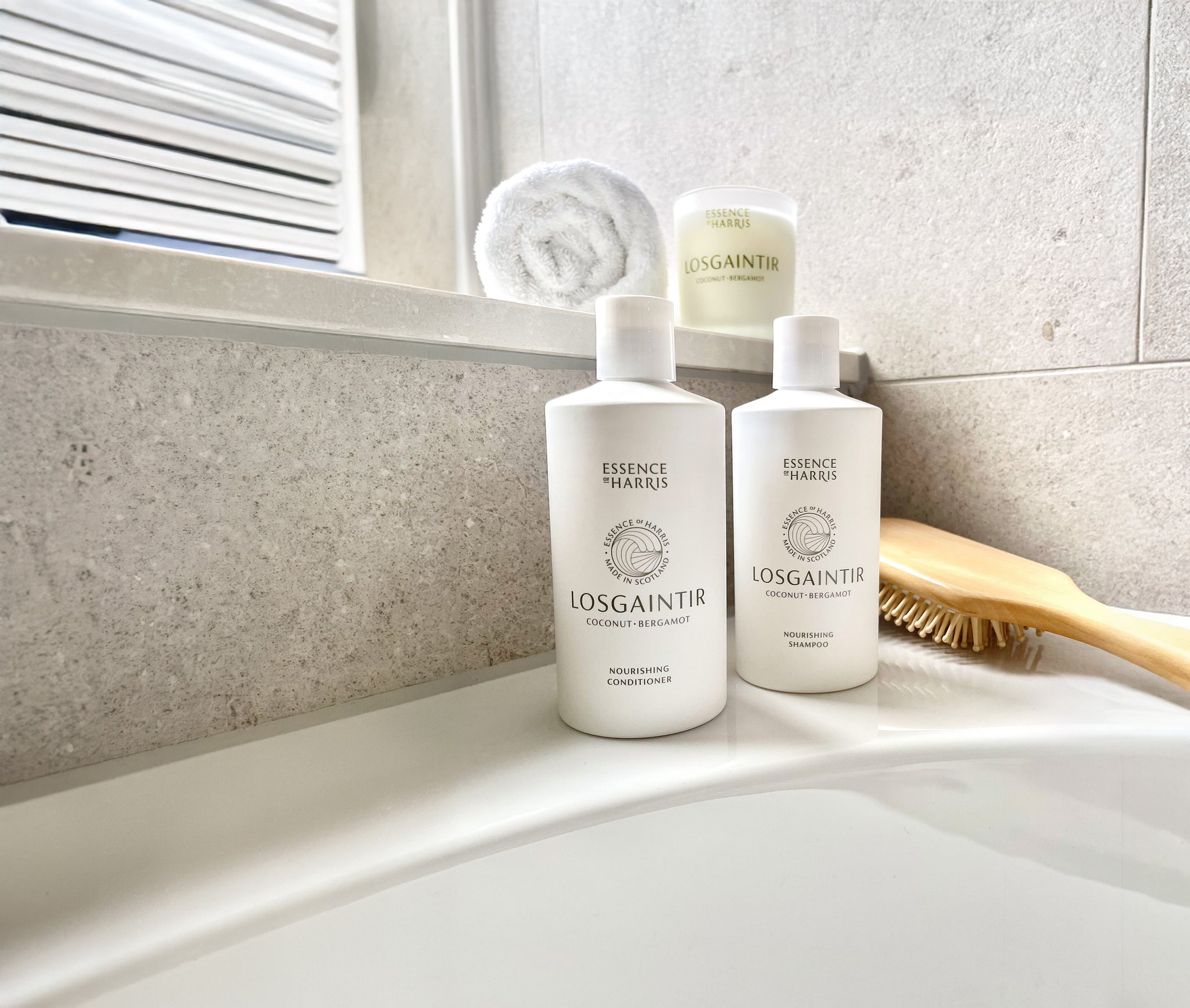 Losgaintir, shampoo and conditioner set on a bath tub with a wooden hair brush