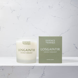 Losgaintir, coconut and bergamot frosted glass soy wax candle on marble background next to green box