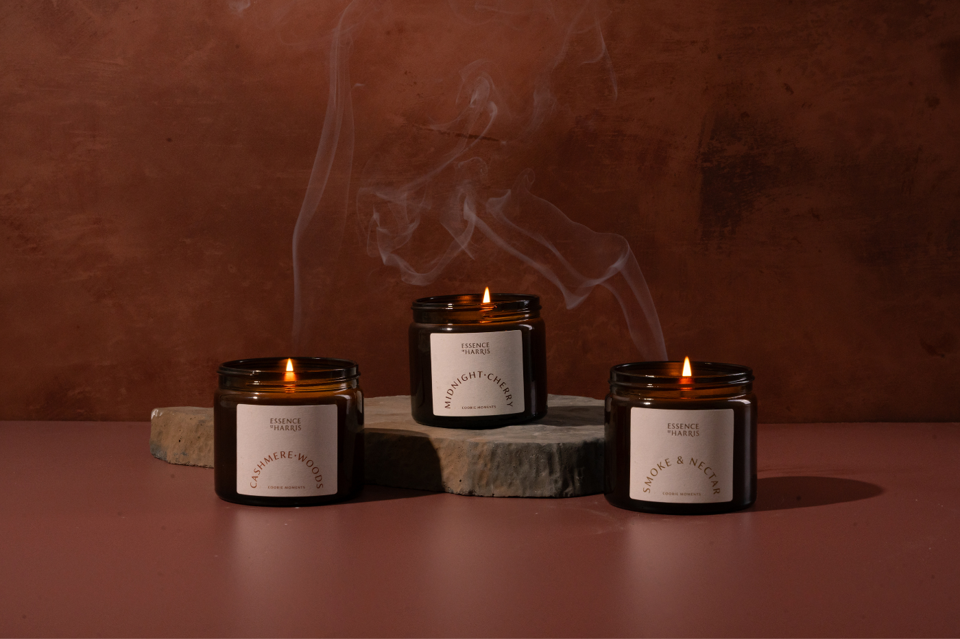 Apothecary style candle jars being held in hands on beige background