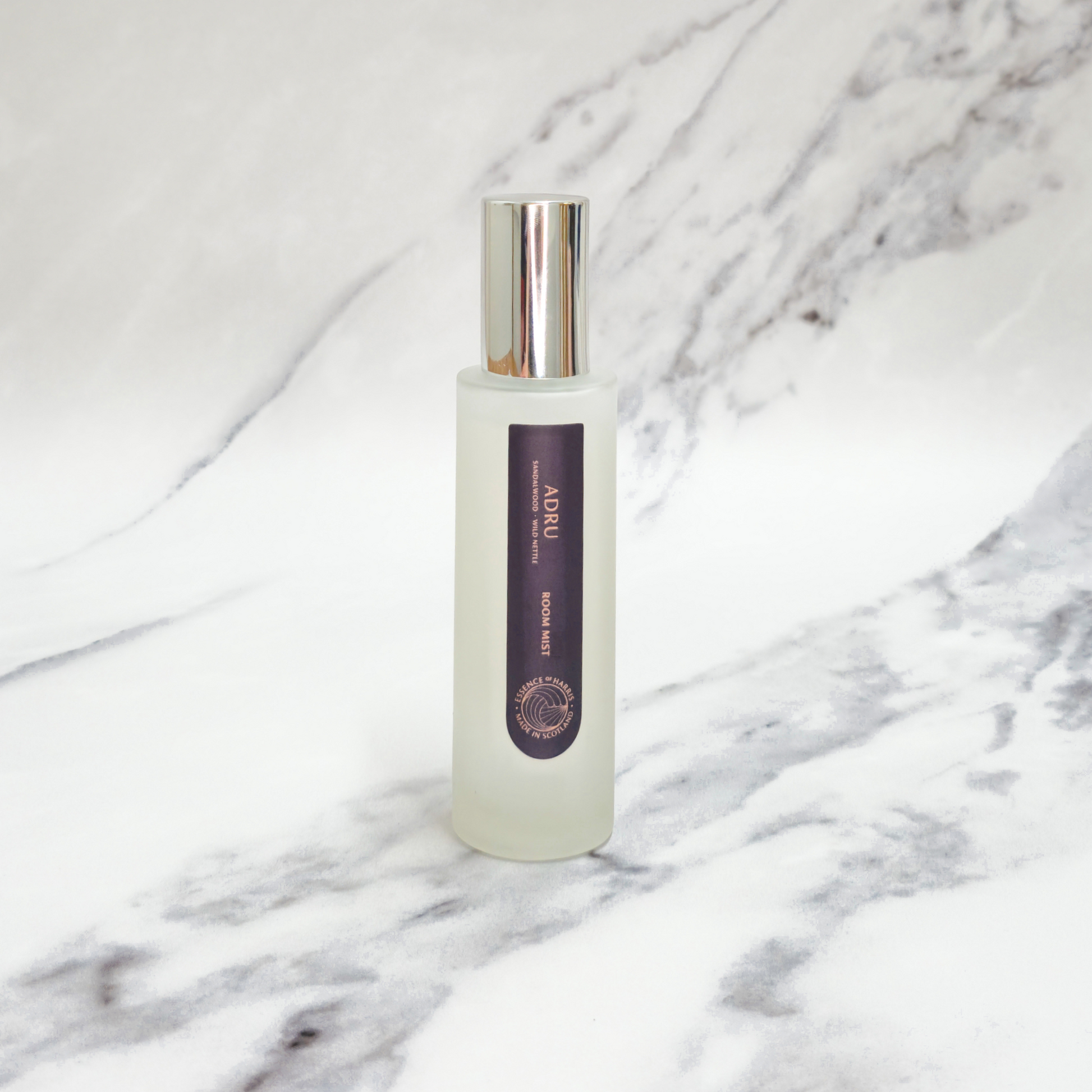 Essence of Harris Adru sandalwood and wild nettle spray on marble backdrop