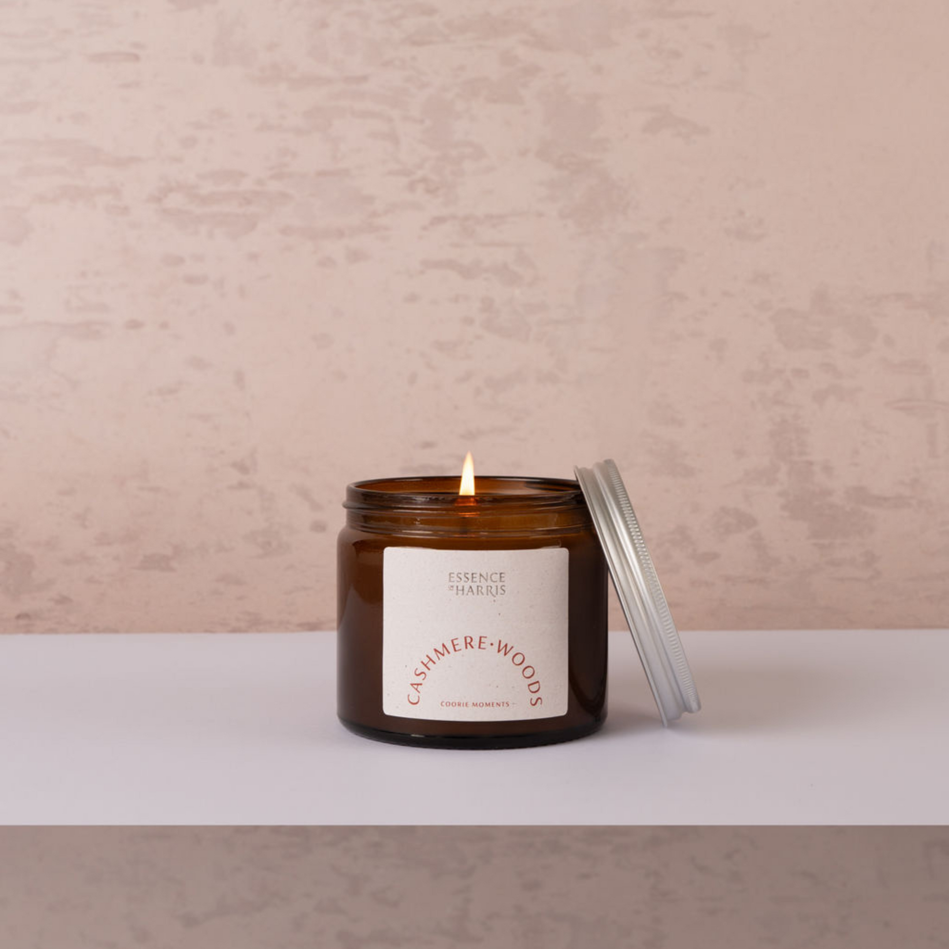 Cashmere woods jar candle, with lit flame on neutral background