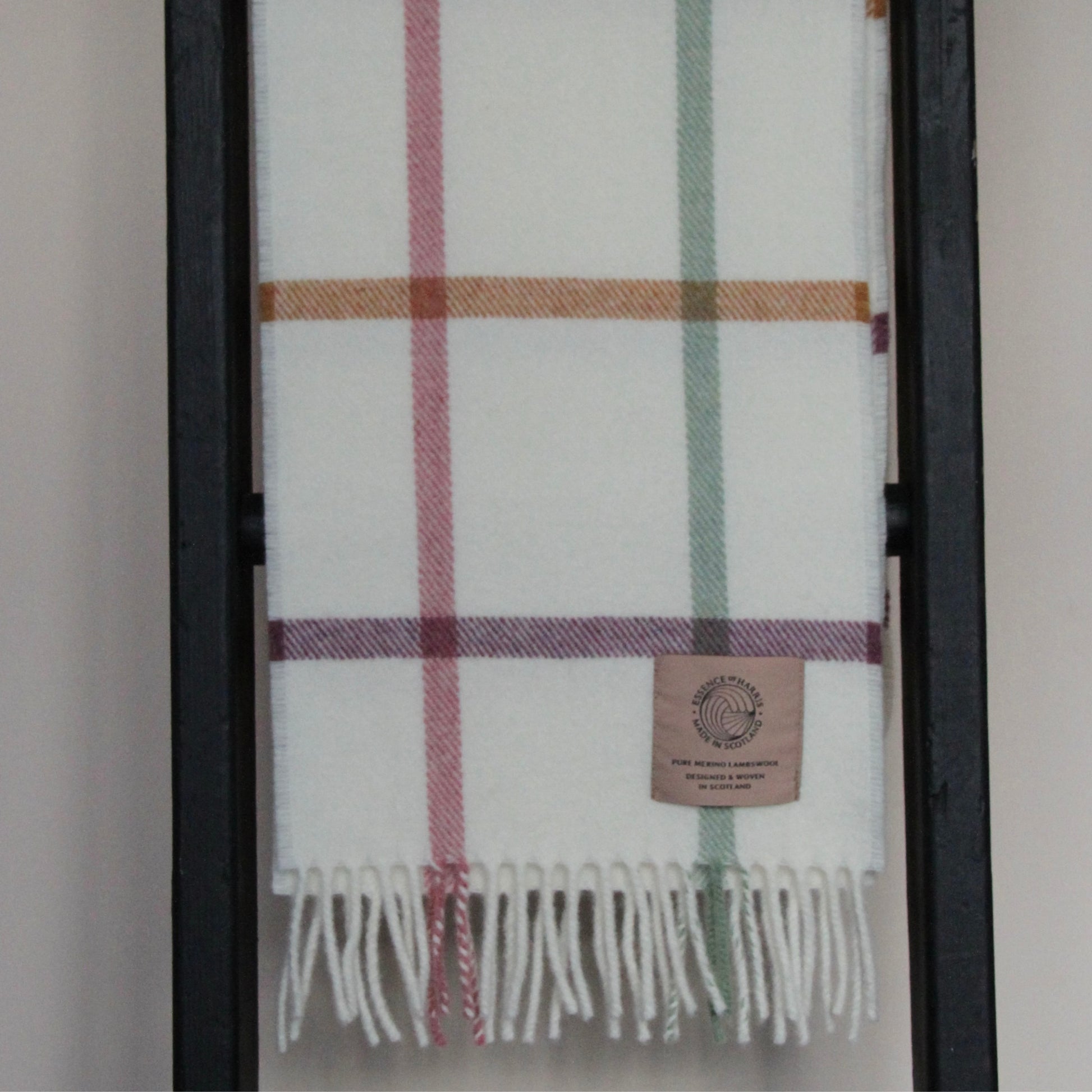 Essence of Harris, Harris Sands pastel checked lambswool scarf draped over wooden ladder