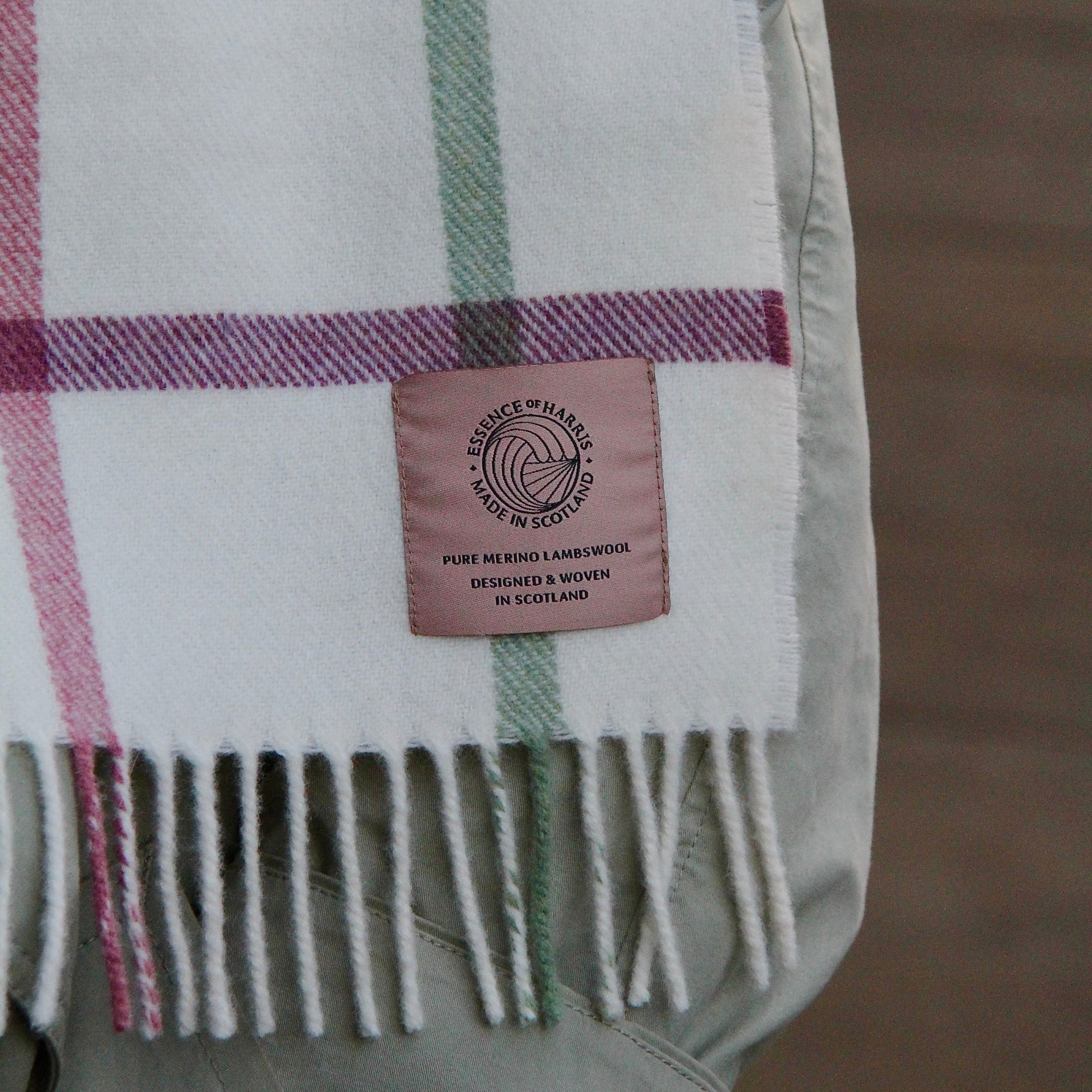 Essence of Harris, Harris Sands pastel checked lambswool scarf draped over arm