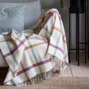 Essence of Harris, Harris Sands pastel checked throw blanket draped over a grey sofa