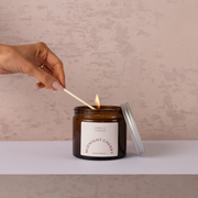 Essence of Harris Midnight Cherry candle in apothecary candle jar, being lit 