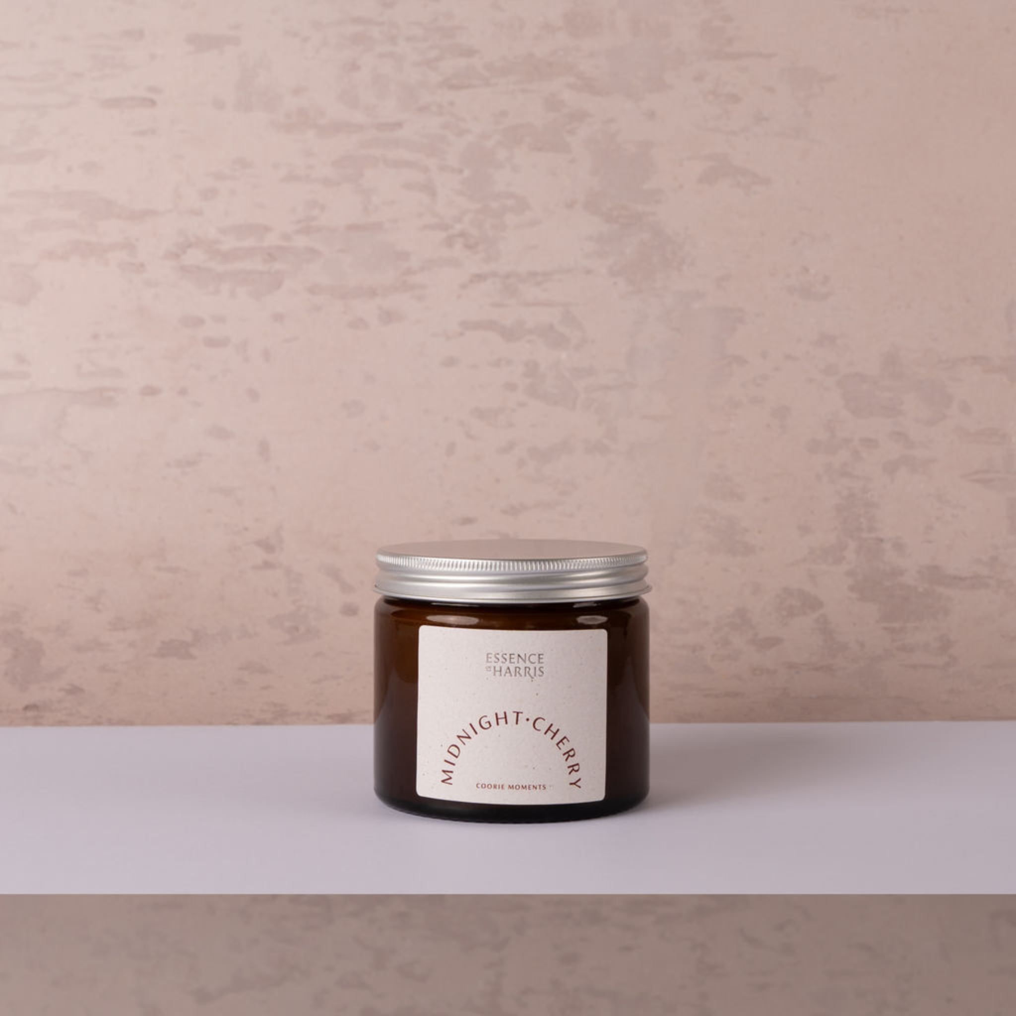 Midnight cherry jar candle with silver lid on neutral backdrop
