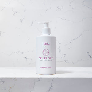 Seilebost, black pomegranate hand and body lotion in a white 300ml pump bottle on a marble background.