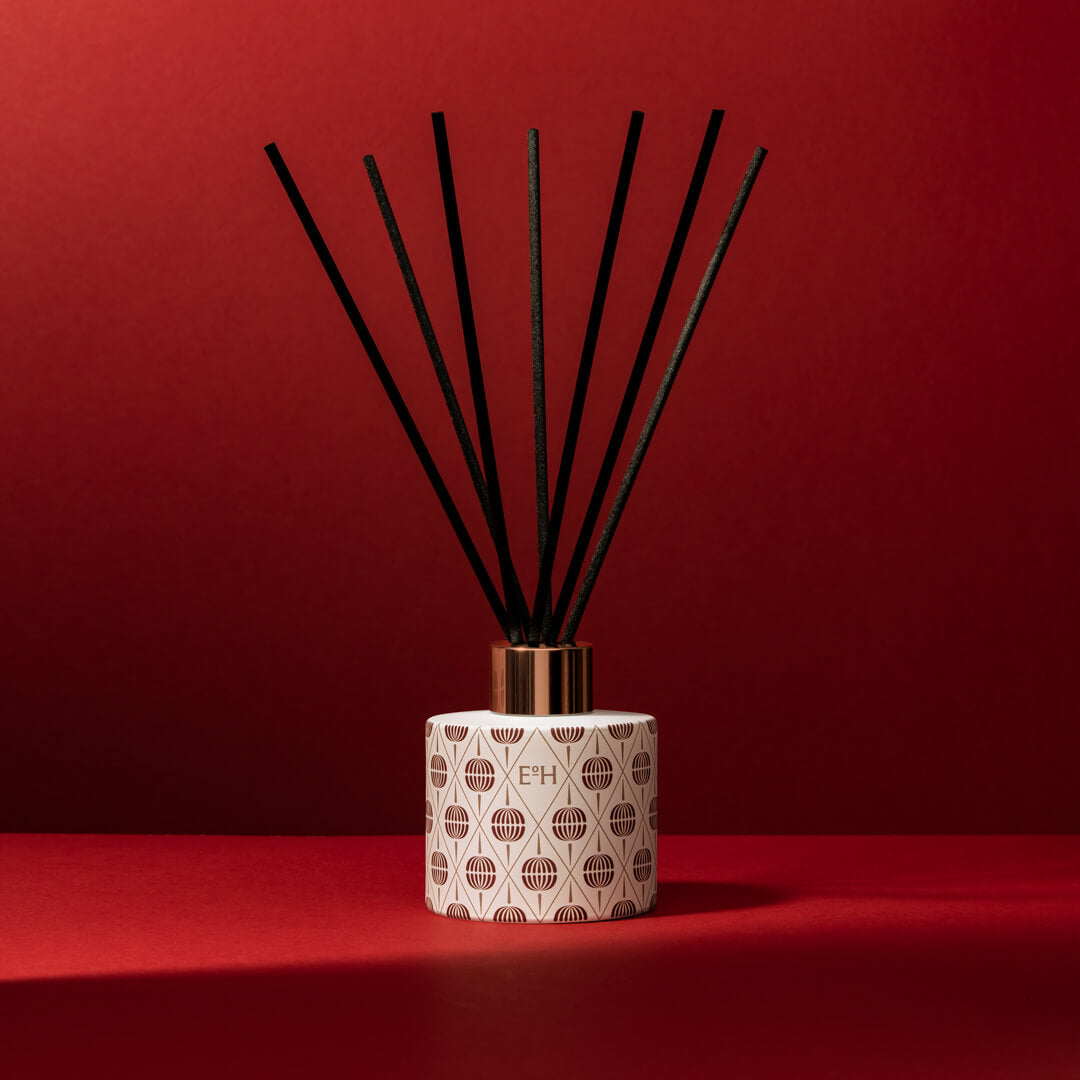 Frosted cranberry Christmas reed diffuser with festive pattern and black reeds