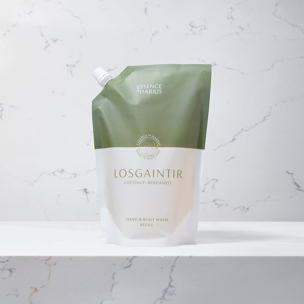 Losgaintir, coconut and bergamot hand and body wash refill in a green and white pouch on a marble background.