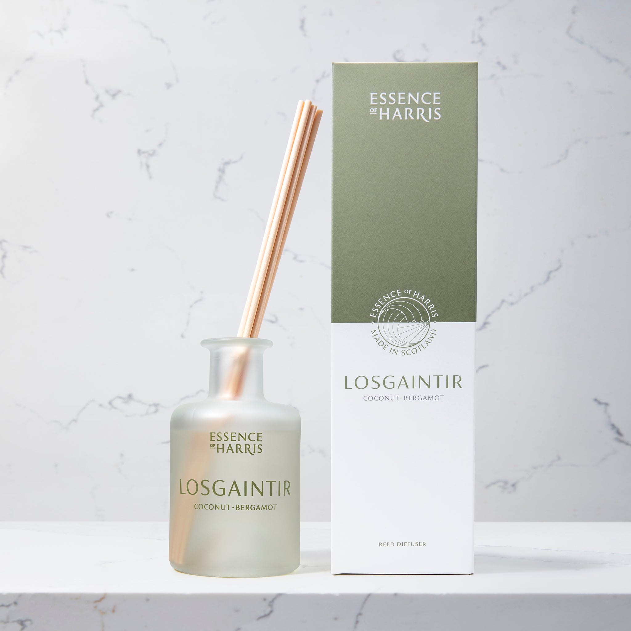 Losgaintir, coconut and bergamot frosted glass reed diffuser on marble background next to green and white box
